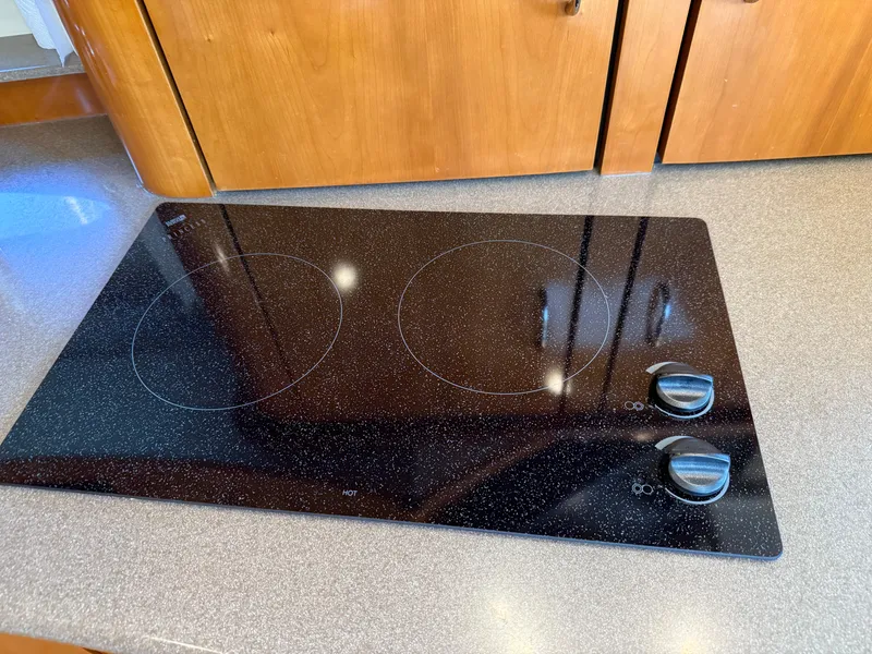 Slide: The Image of Stovetop in 2006 Carver 36 Mariner yacht kitchen, featuring two burners and wooden cabinetry. - 38