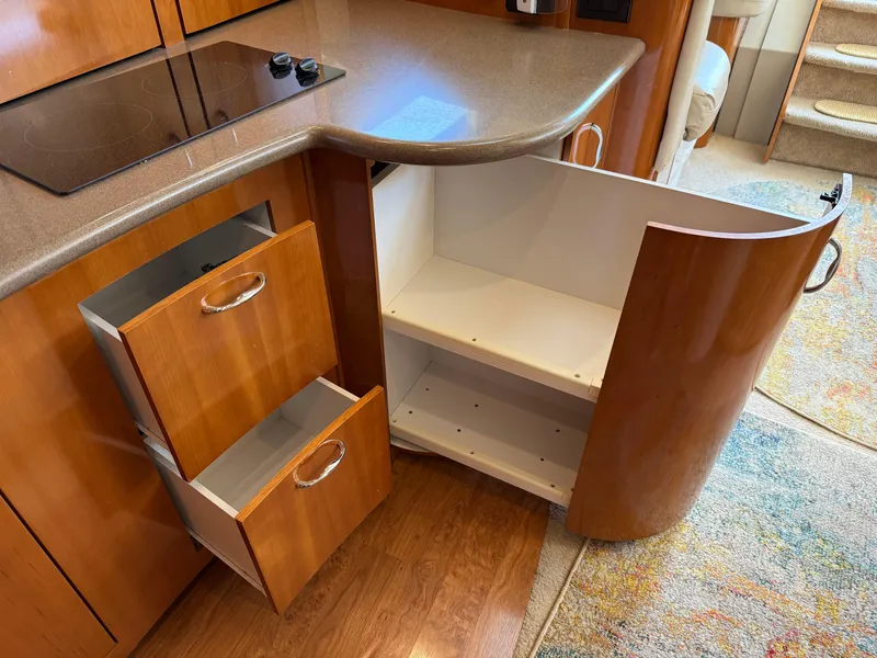 Slide: The Image of 2006 Carver 36 Mariner kitchen with open cabinets and drawers, featuring a sleek countertop. - 39