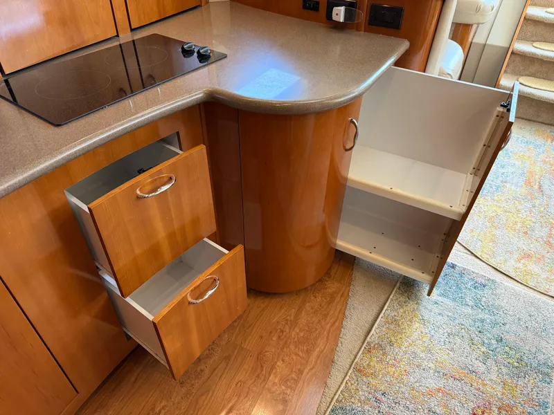 Slide: The Image of 2006 Carver 36 Mariner kitchen with open cabinets and drawers, featuring a sleek countertop. - 40