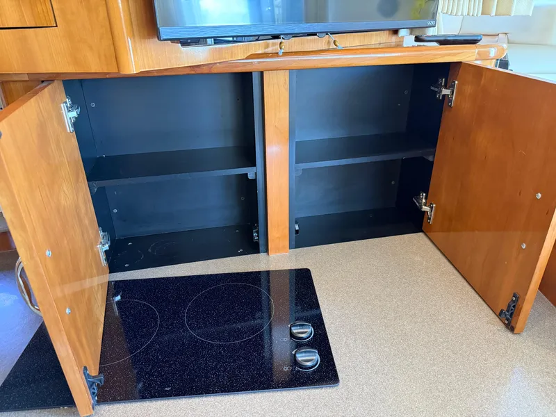 Slide: The Image of Open wooden cabinets and stovetop in 2006 Carver 36 Mariner yacht kitchen. - 42