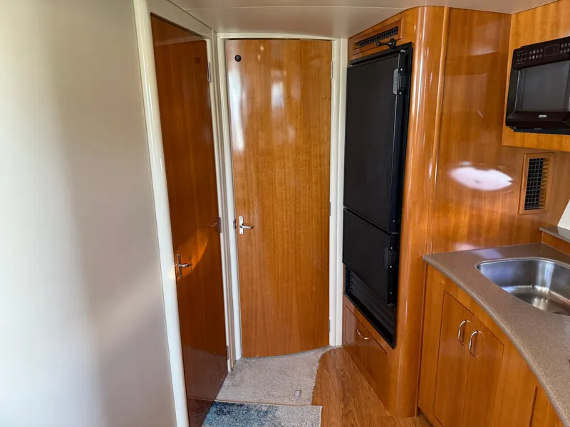 Slide: The Image of Interior of 2006 Carver 36 Mariner yacht with wood cabinetry and compact kitchen area. - 43