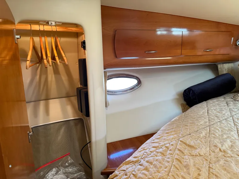 Slide: The Image of Interior of 2006 Carver 36 Mariner with closet and bed, featuring wooden cabinetry. - 49