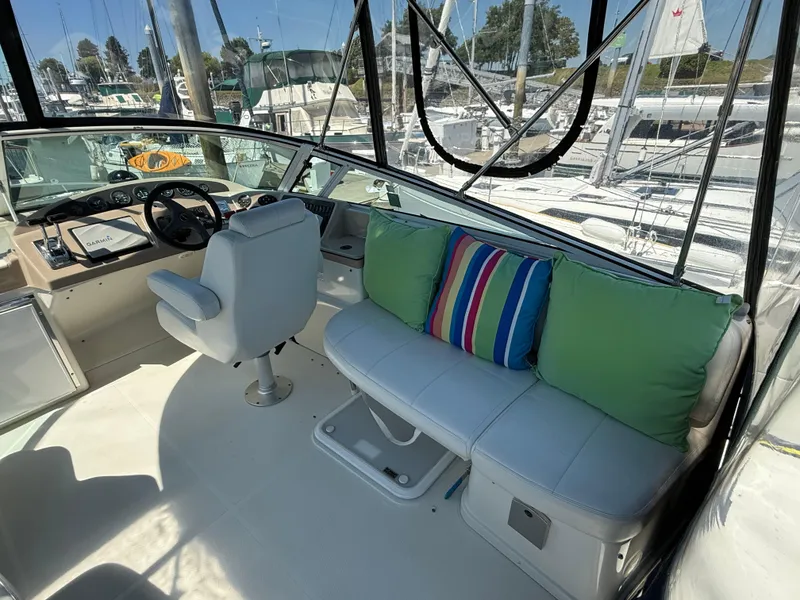 Slide: The Image of 2006 Carver 36 Mariner cockpit with white seating, colorful cushions, and steering console. - 9