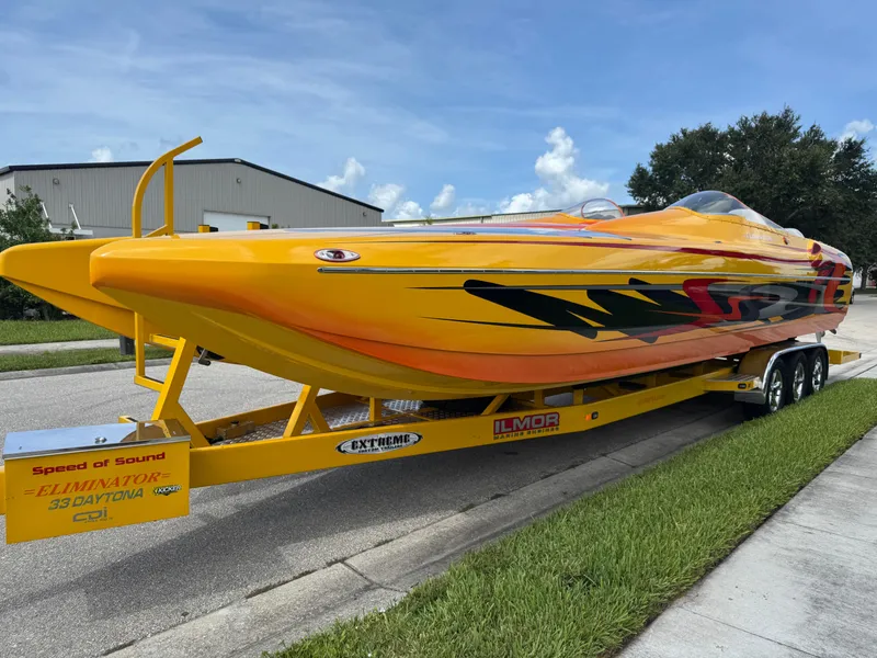 Slide: The Image of 2006 Eliminator 33 Daytona speedboat on trailer, vibrant yellow with bold graphics. - 10