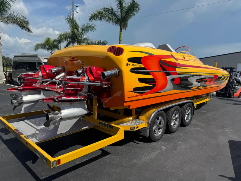 Slide: The Image of 2006 Eliminator 33 Daytona speedboat with vibrant orange and red design on a trailer. - 14
