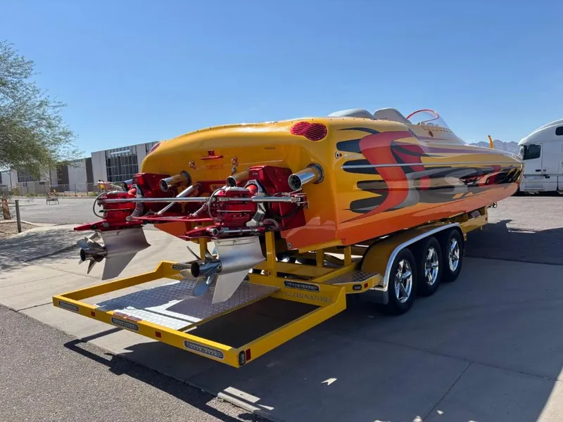 Slide: The Image of 2006 Eliminator 33 Daytona speedboat on trailer, vibrant yellow and red design, parked outdoors. - 16