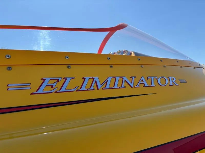 Slide: The Image of Yellow 2006 Eliminator 33 Daytona boat with bold logo under clear blue sky. - 17