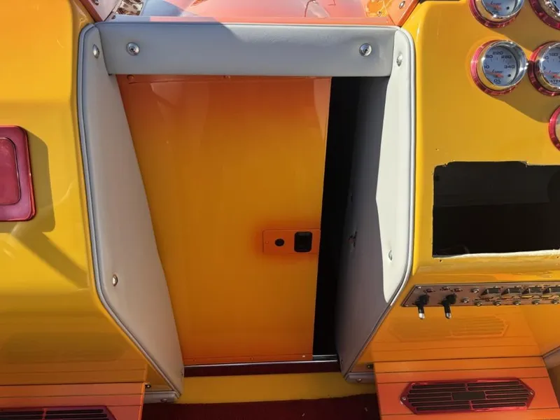 Slide: The Image of 2006 Eliminator 33 Daytona boat dashboard with vibrant yellow and orange design, featuring gauges and controls. - 20