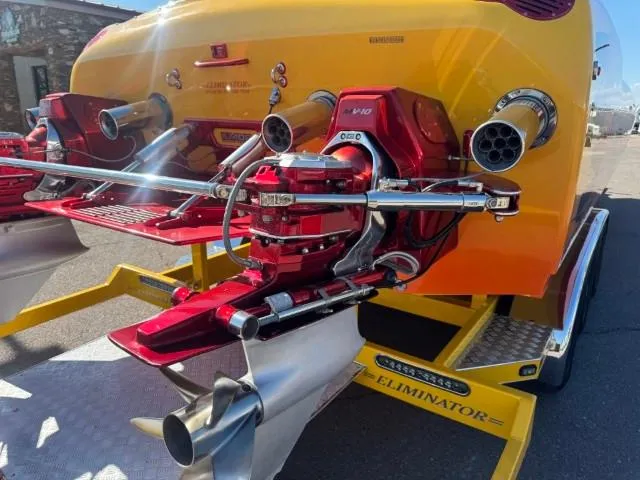 Slide: The Image of 2006 Eliminator 33 Daytona boat with vibrant red and yellow detailing, featuring powerful dual engines. - 26