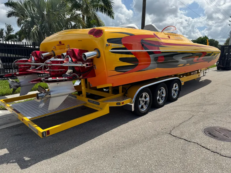 Slide: The Image of 2006 Eliminator 33 Daytona speedboat with vibrant graphics on a yellow trailer. - 3