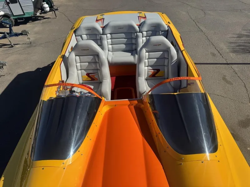 Slide: The Image of 2006 Eliminator 33 Daytona speedboat with vibrant yellow and orange design, featuring sleek seating. - 32