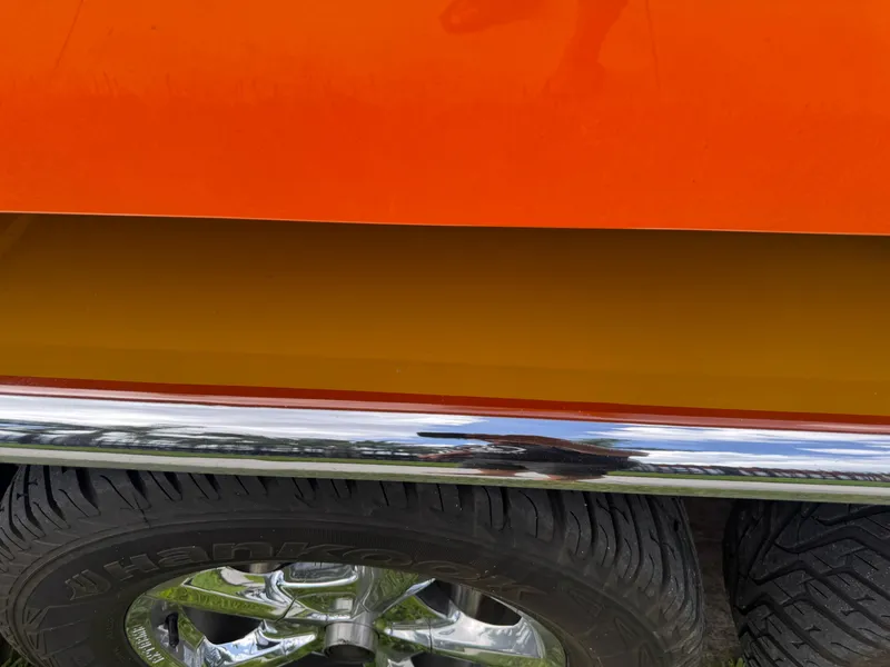 Slide: The Image of Close-up of 2006 Eliminator 33 Daytona, showcasing orange and yellow paint with chrome detailing. - 9