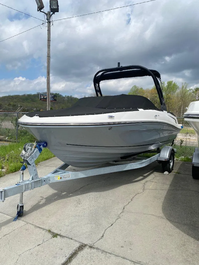 The Image of 2025 Bayliner VR5 Bowrider I/O boat on trailer, parked outdoors under cloudy sky. - 0