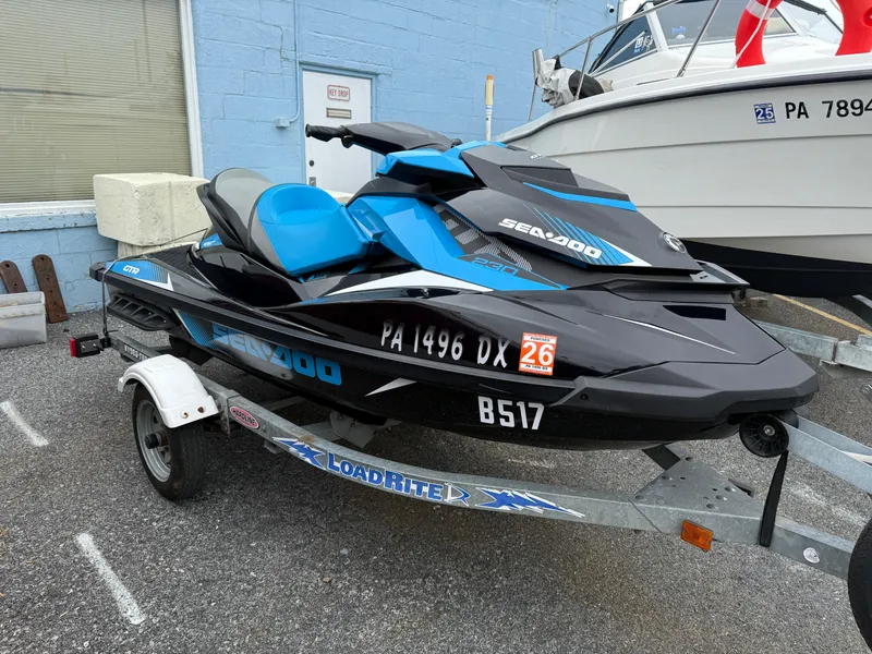 Slide: The Image of 2019 Sea-Doo GTR 230 jet ski on trailer, parked outdoors. - 2