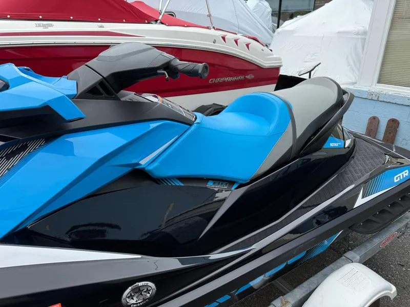 Slide: The Image of 2019 Sea-Doo GTR 230 jet ski with blue and black design on a trailer. - 3