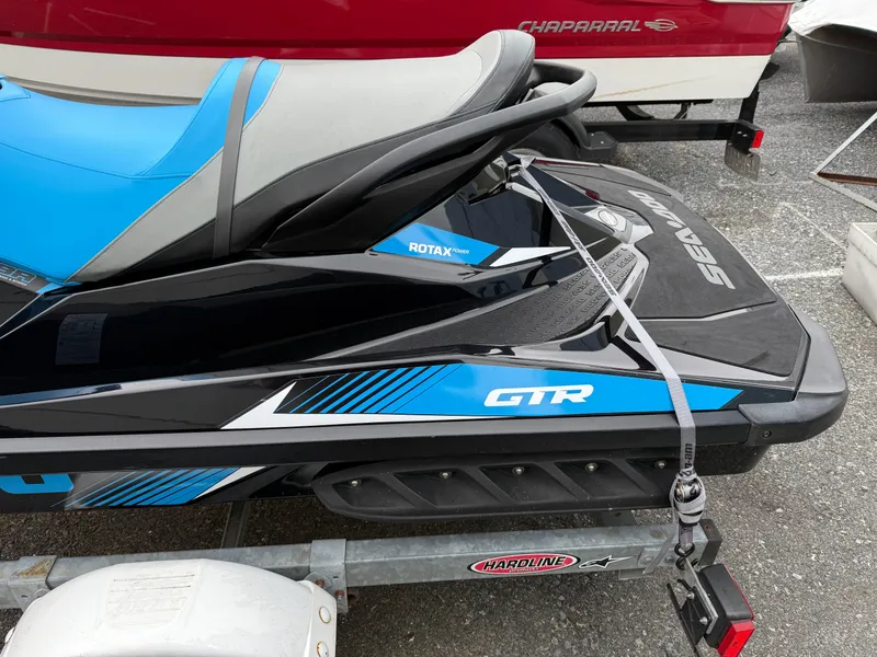 Slide: The Image of 2019 Sea-Doo GTR 230 jet ski with blue and black design on a trailer. - 4