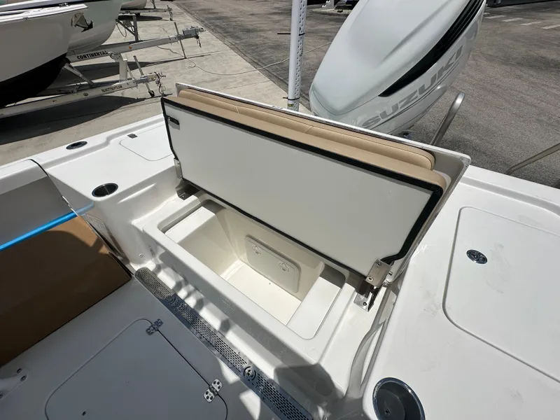 Slide: The Image of 2026 Sea Pro 250 Bay boat with open storage compartment and Suzuki engine. - 11