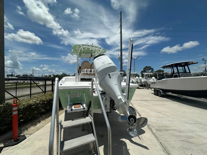 Slide: The Image of 2026 Sea Pro 250 Bay boat with outboard motor, parked outdoors under a clear blue sky. - 3