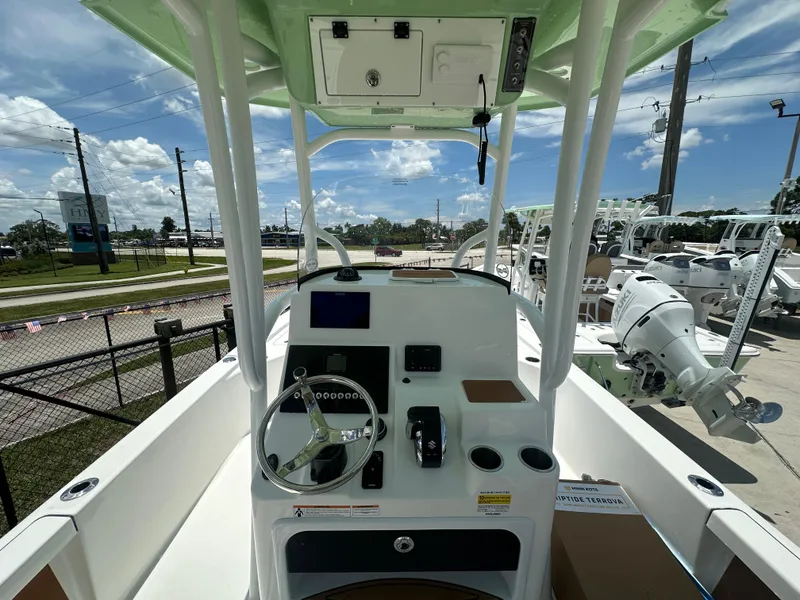 Slide: The Image of 2026 Sea Pro 250 Bay boat interior with steering wheel and control panel, parked outdoors. - 4