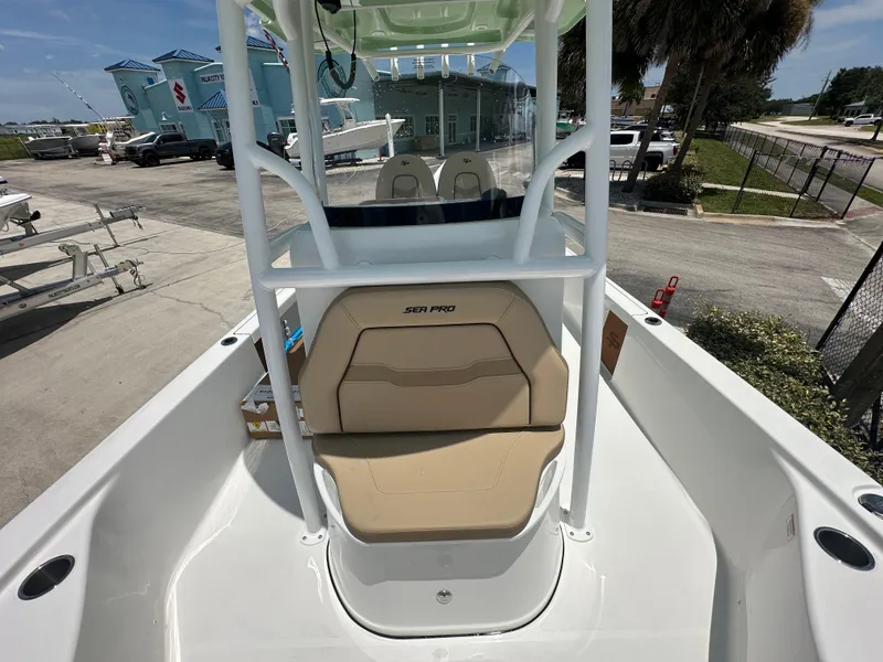 Slide: The Image of 2026 Sea Pro 250 Bay boat interior with tan seating, docked at a marina. - 9