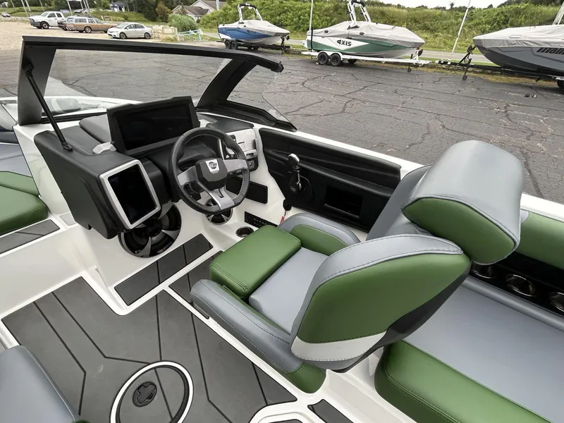 Slide: The Image of 2021 Malibu Wakesetter 21 VLX interior with green and gray seating, modern dashboard, and steering wheel. - 10