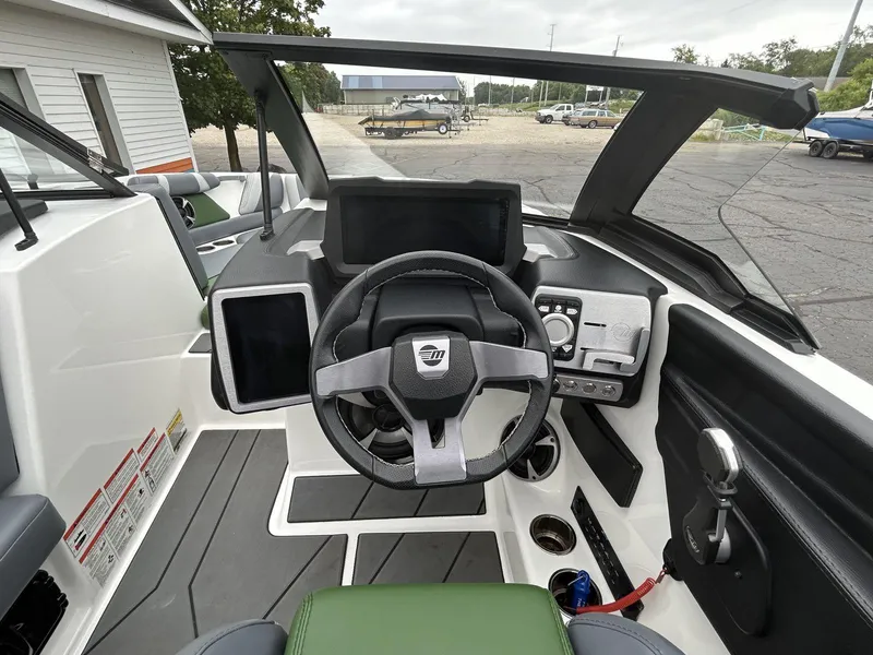 Slide: The Image of 2021 Malibu Wakesetter 21 VLX boat dashboard with steering wheel and control panel. - 11