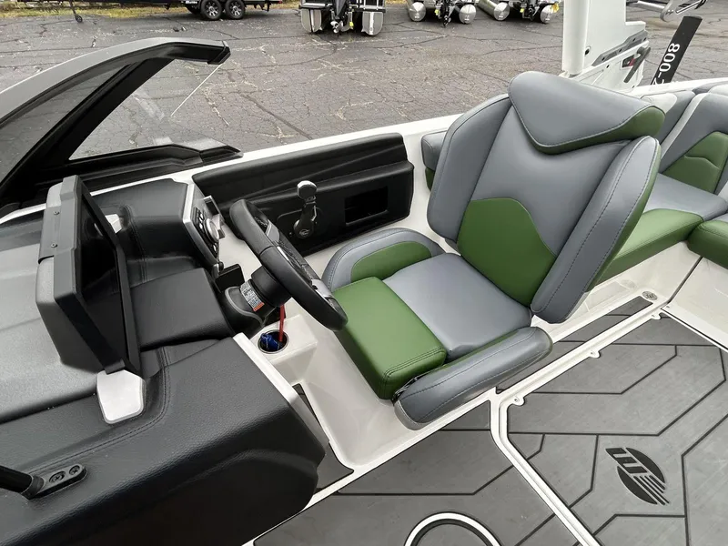 Slide: The Image of 2021 Malibu Wakesetter 21 VLX interior with green and gray seating, steering wheel, and dashboard. - 15