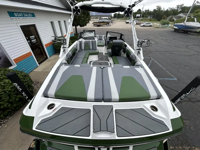 Slide: The Image of 2021 Malibu Wakesetter 21 VLX boat with green and gray interior at a boat sales lot. - 7