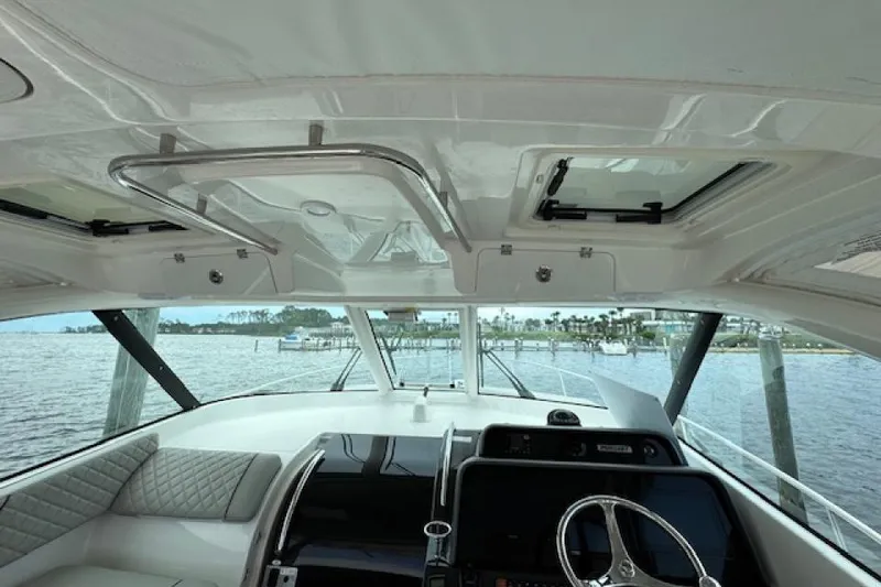 Slide: The Image of Interior view of 2022 Pursuit OS 385 Offshore boat, featuring helm and seating area. - 11