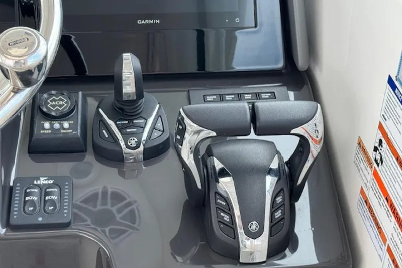 Slide: The Image of Control panel of 2022 Pursuit OS 385 Offshore boat with steering and throttle controls. - 14