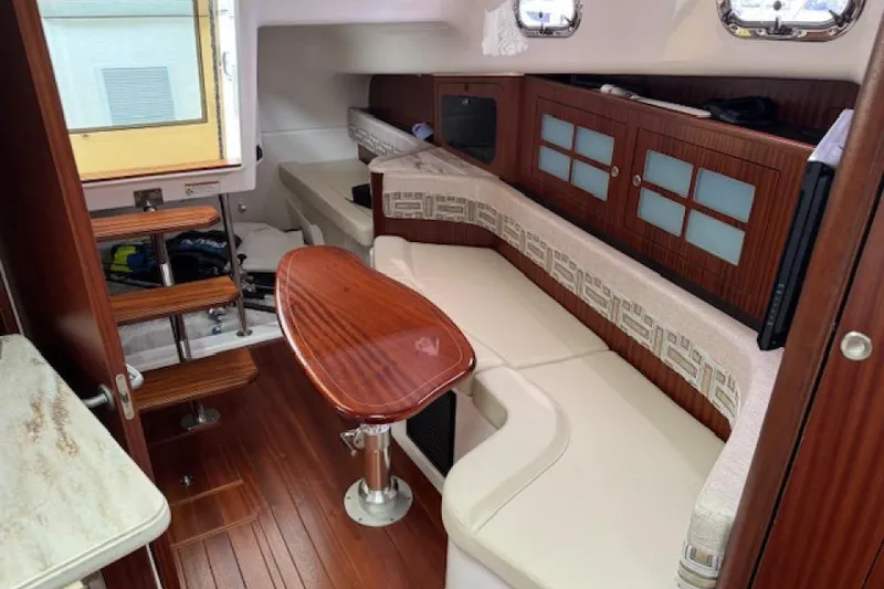 Slide: The Image of 2022 Pursuit OS 385 Offshore cabin interior with wooden finishes and seating area. - 17