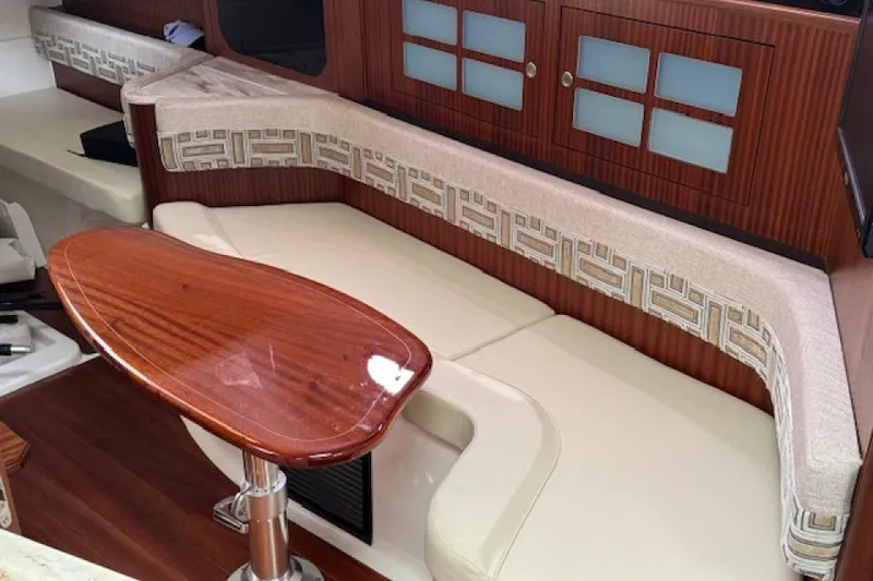 Slide: The Image of Interior of 2022 Pursuit OS 385 Offshore boat with elegant seating and wooden table. - 18