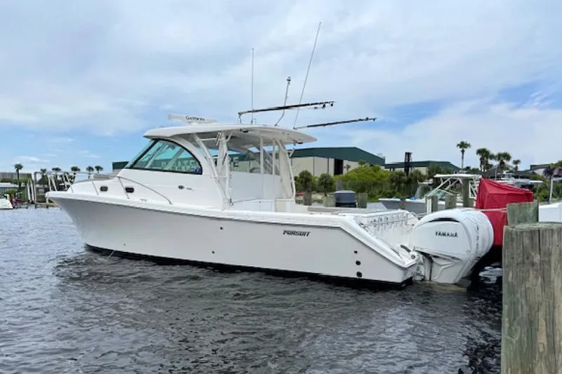 The Image of 2022 Pursuit OS 385 Offshore boat docked with Yamaha engines, under a partly cloudy sky. - 2