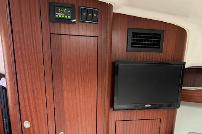 Slide: The Image of Interior of 2022 Pursuit OS 385 Offshore with wood paneling and mounted TV. - 21