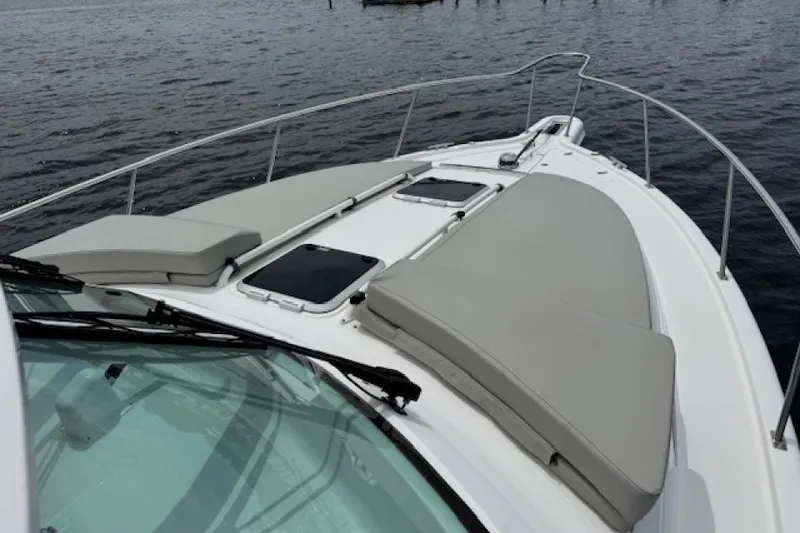 Slide: The Image of 2022 Pursuit OS 385 Offshore boat deck with cushioned seating on calm water. - 4