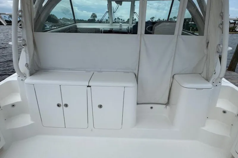 Slide: The Image of 2022 Pursuit OS 385 Offshore boat interior with white storage compartments. - 8
