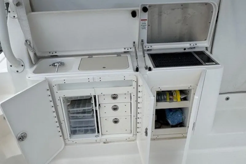 Slide: The Image of 2022 Pursuit OS 385 Offshore boat kitchen with storage cabinets and sink. - 9