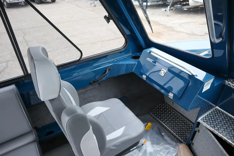 Slide: The Image of Interior of 2025 Hewescraft 240 Ocean Pro ET HT boat, featuring gray seating and blue dashboard. - 13