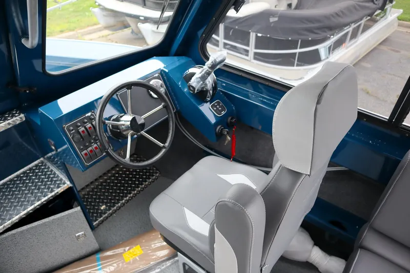 Slide: The Image of Interior of 2025 Hewescraft 240 Ocean Pro ET HT boat, featuring steering wheel and controls. - 14