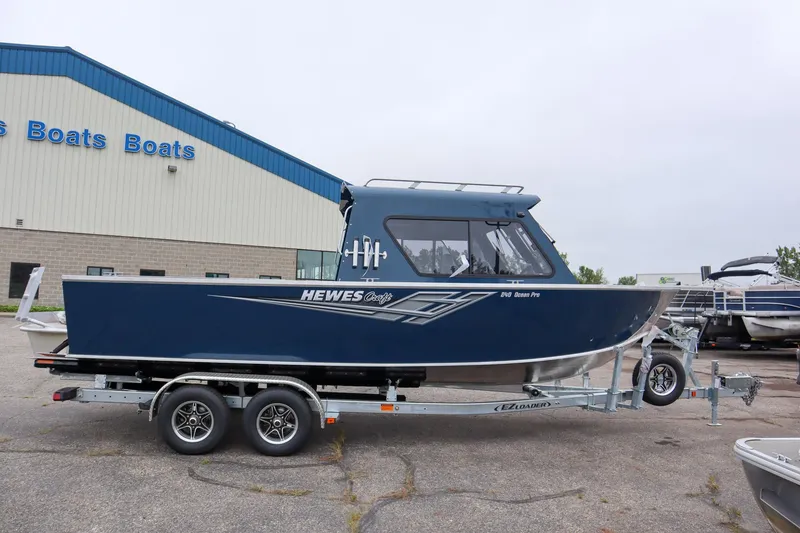 Slide: The Image of 2025 Hewescraft 240 Ocean Pro ET HT boat on trailer outside dealership. - 2
