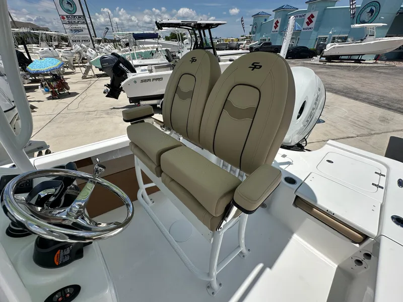 Slide: The Image of 2026 Sea Pro 230 Bay boat interior with dual seats and steering wheel, displayed at a dealership. - 13