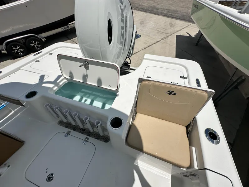 Slide: The Image of 2026 Sea Pro 230 Bay boat interior with storage compartments and rod holders. - 14