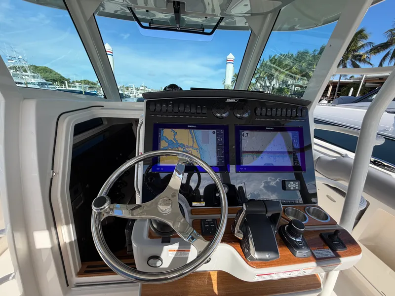 Slide: The Image of The cockpit of the 2026 Boston Whaler 380 Outrage features modern navigation systems and controls. - 29