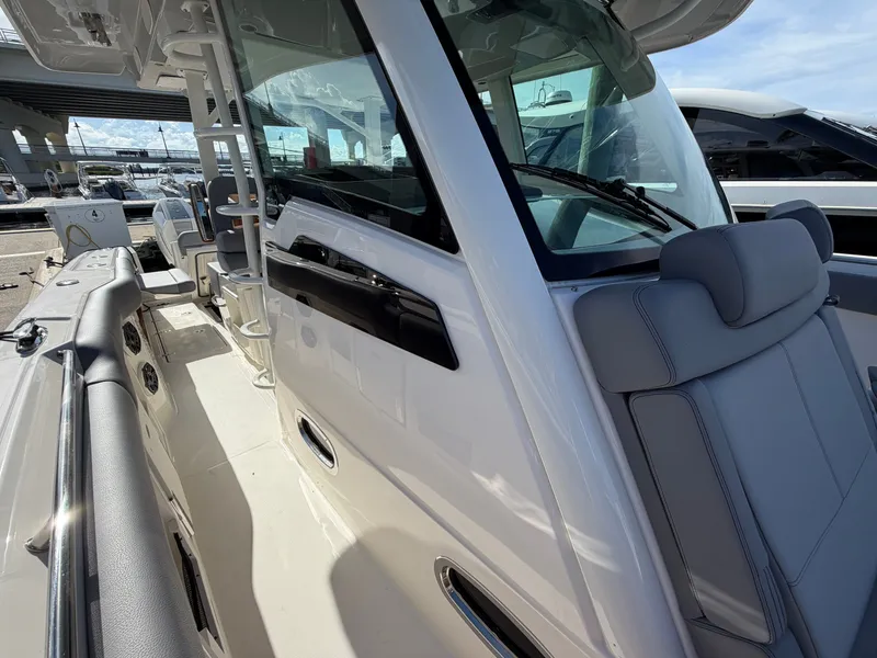 Slide: The Image of The image shows the cockpit of a 2026 Boston Whaler 380 Outrage with gray seating. - 21