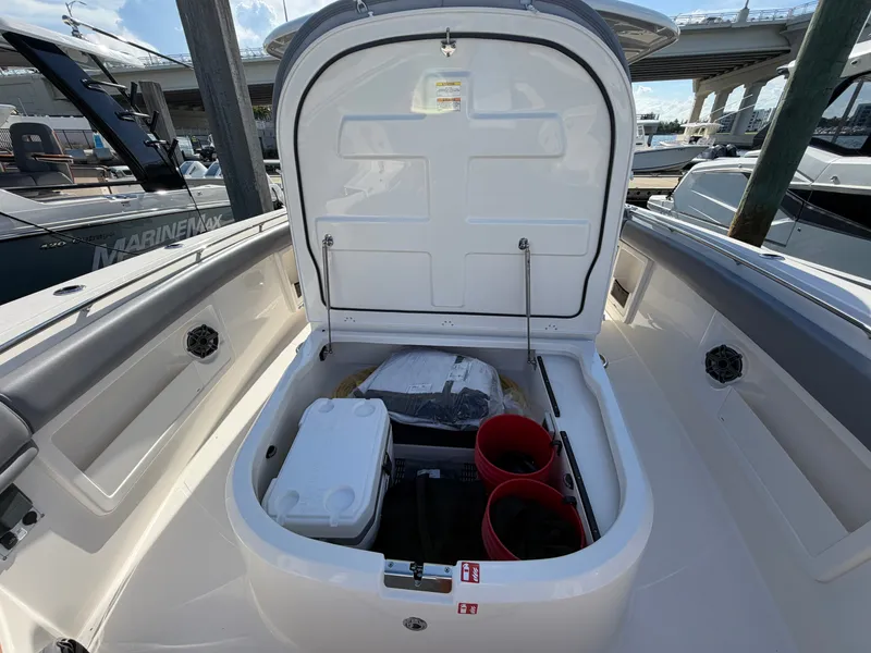 Slide: The Image of The bow storage of the Boston Whaler 380 Outrage is open, revealing buckets and equipment. - 18