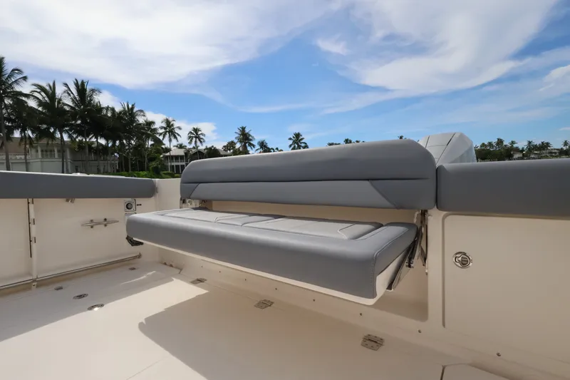 Slide: The Image of Boston Whaler 380 Outrage 2027: Spacious outdoor seating with gray cushions under a blue sky. - 25