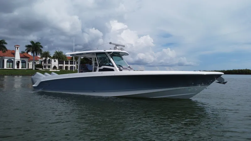 Slide: The Image of Boston Whaler 380 Outrage from 2027 on calm water near a villa. - 3