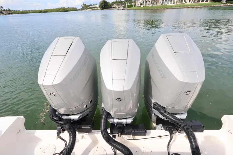 Slide: The Image of Three powerful outboard engines on a boat in calm waters. - 19