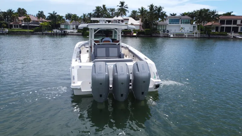 Slide: The Image of A 2027 Boston Whaler 380 Outrage on the water, featuring four outboard engines and a modern cabin. - 8