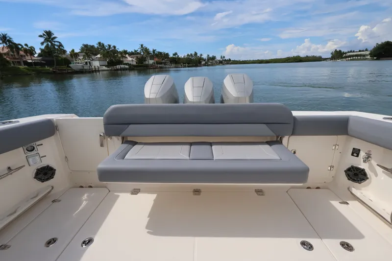 Slide: The Image of The image shows the stern of a Boston Whaler 380 Outrage with three engines and a gray bench. - 24